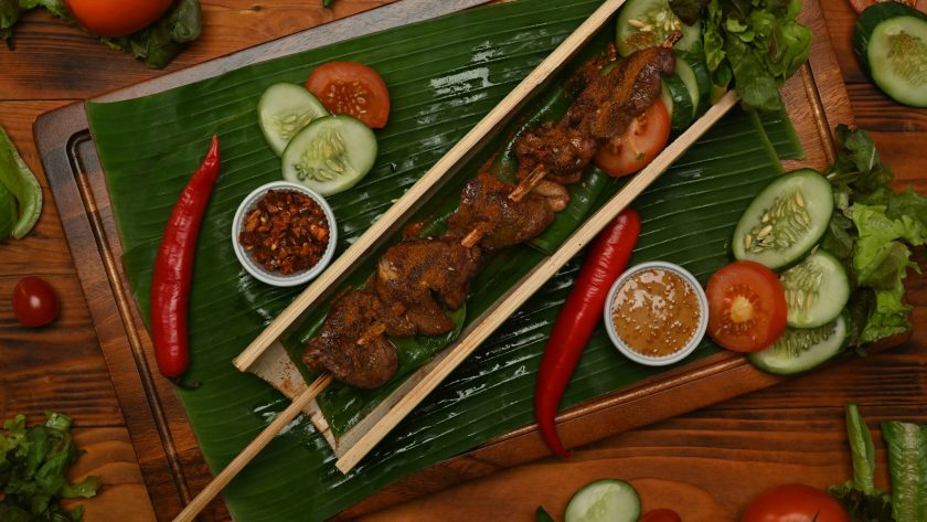 Top view of grilled meat served in bamboo barrel plat with Sichuan pepper.